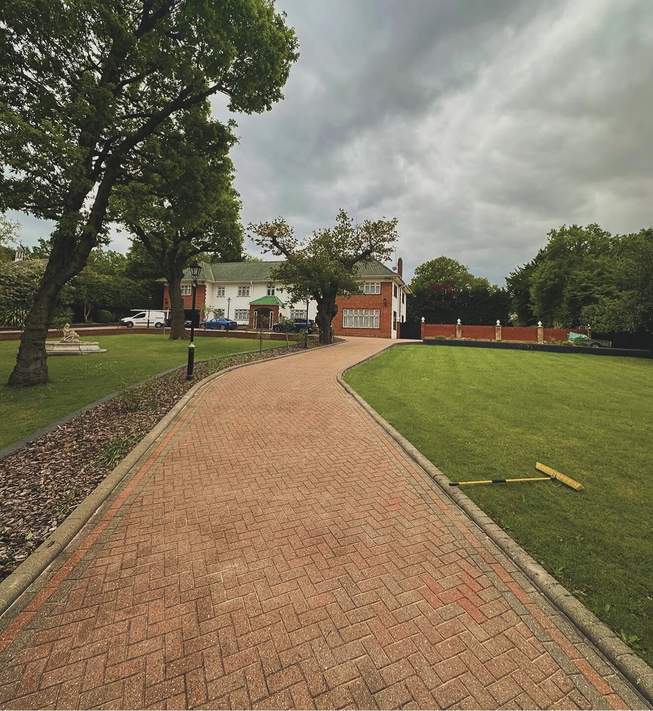 Freshly cleaned herringbone block paving driveway leading up to a house
